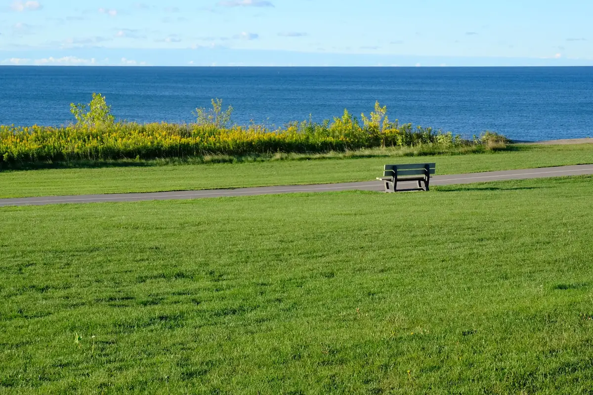A bench beside the Waterfront Trail on the green lawns above Lake Ontario, Ajax, Ontario
