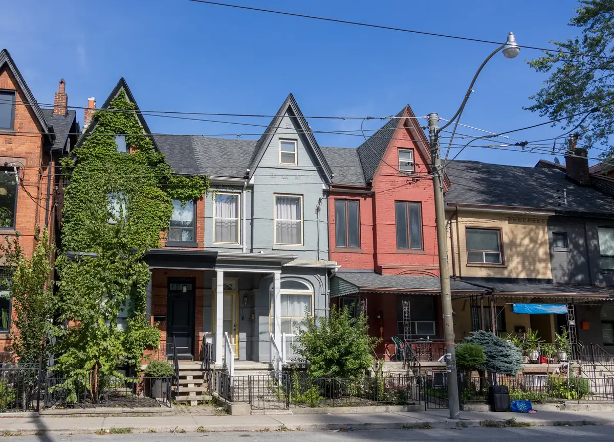 Sunlit Victorian row houses with steep gables along Shaw Street, Toronto