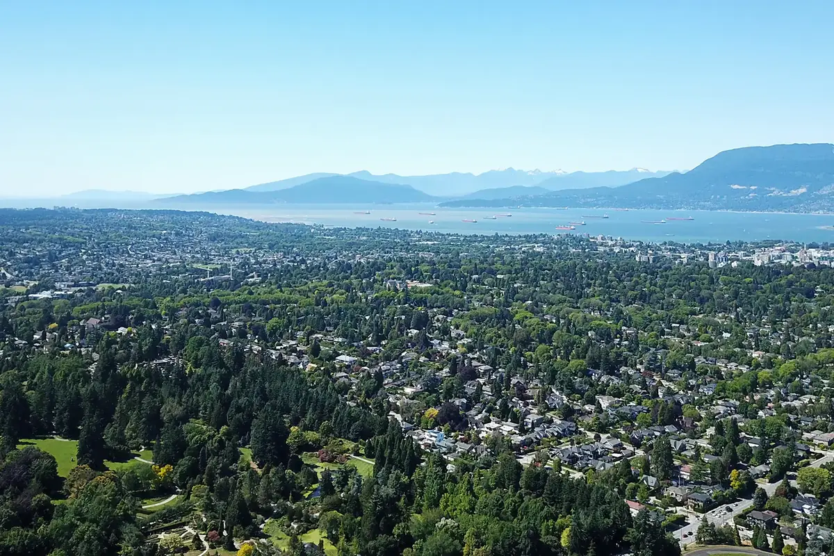 Aerial view over Shaughnessy’s tree-canopied streets toward English Bay and the North Shore Mountains, Vancouver