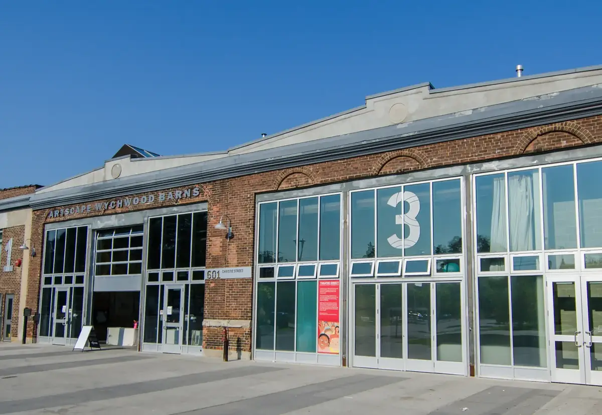 Restored brick streetcar barns of Artscape Wychwood Barns under a clear blue sky, near St. Clair Avenue West, Toronto