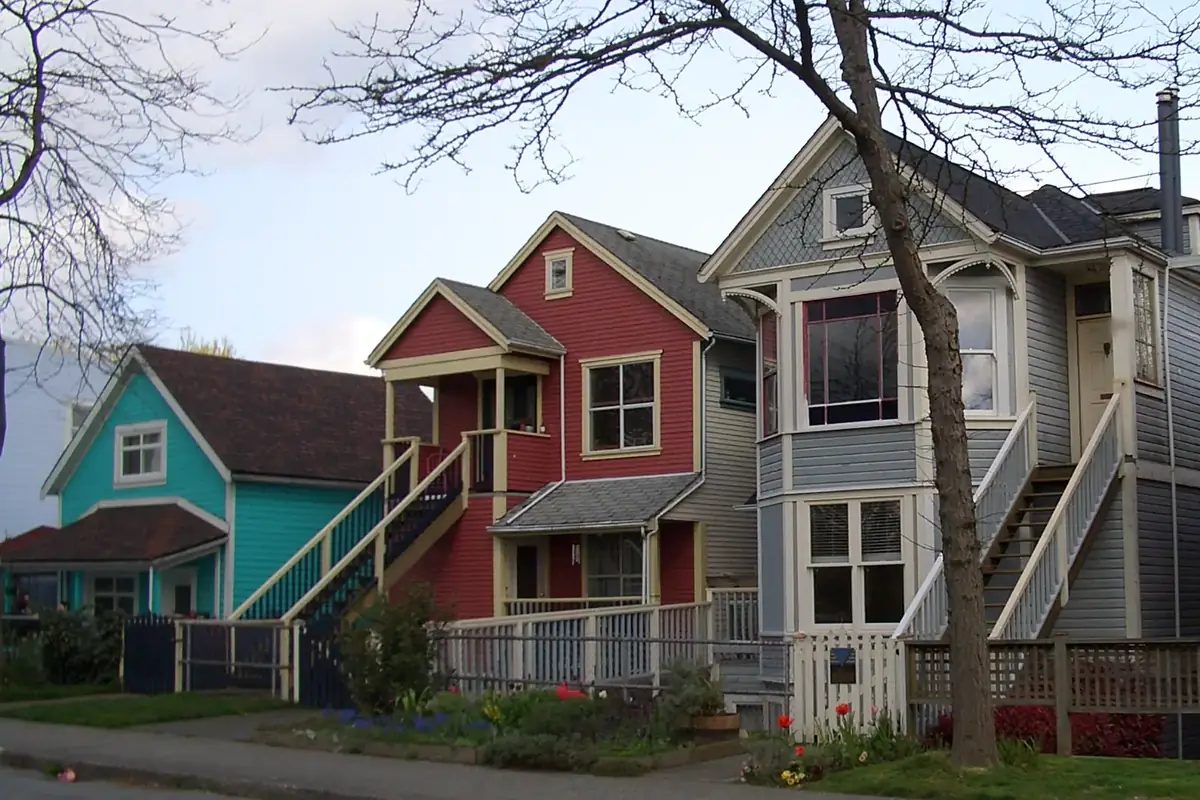 Row of brightly painted Victorian heritage houses with spring tulips in Strathcona, Vancouver