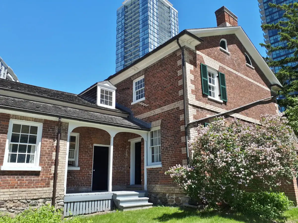 The heritage Gibson House with lilacs in bloom and new condo towers behind, Willowdale, Toronto