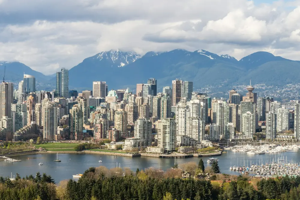 Downtown Vancouver towers and a marina, with the North Shore Mountains behind