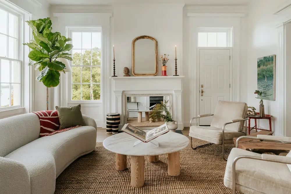 Bright family living room with tall windows, a white fireplace, a curved cream sofa and a jute rug