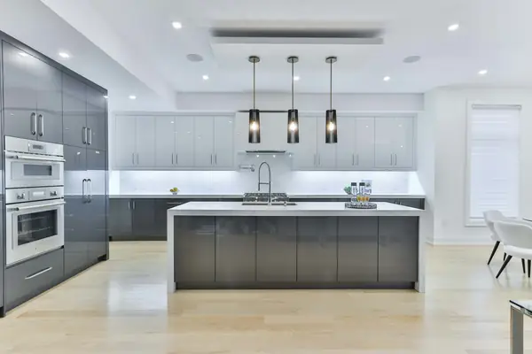 Bright open kitchen with charcoal cabinets, a white island and black pendant lights