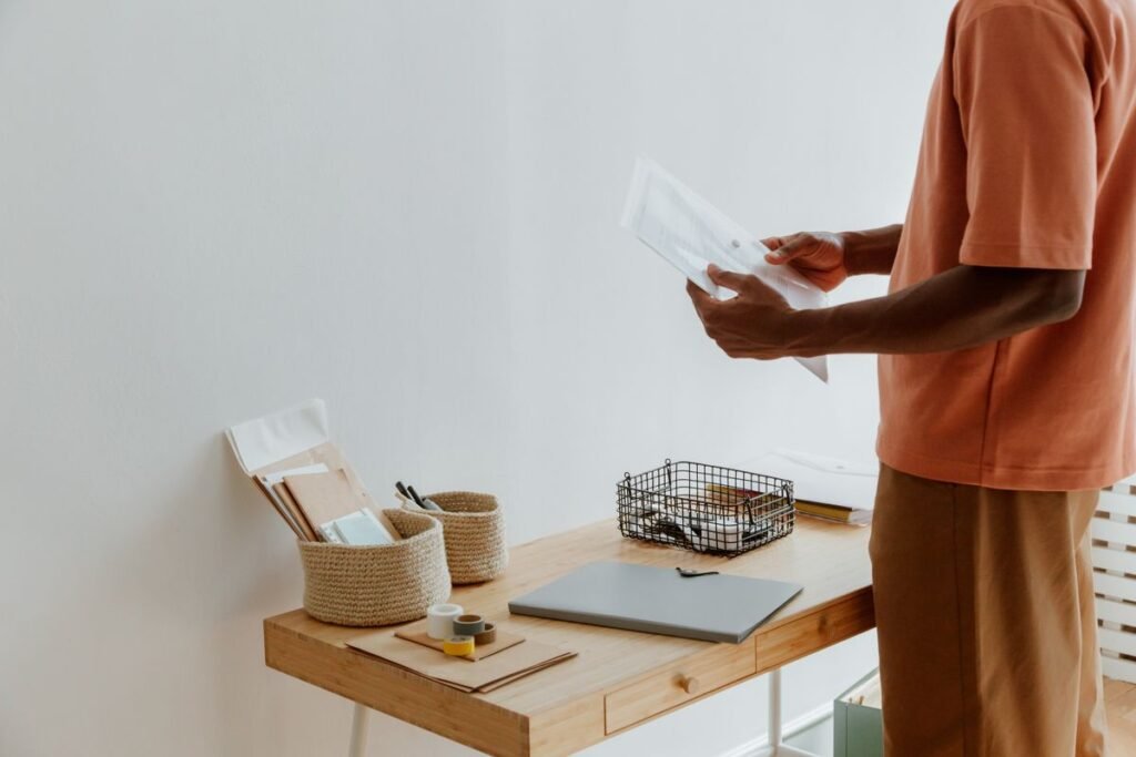 Person reviewing documents at a tidy wooden desk with office supplies
