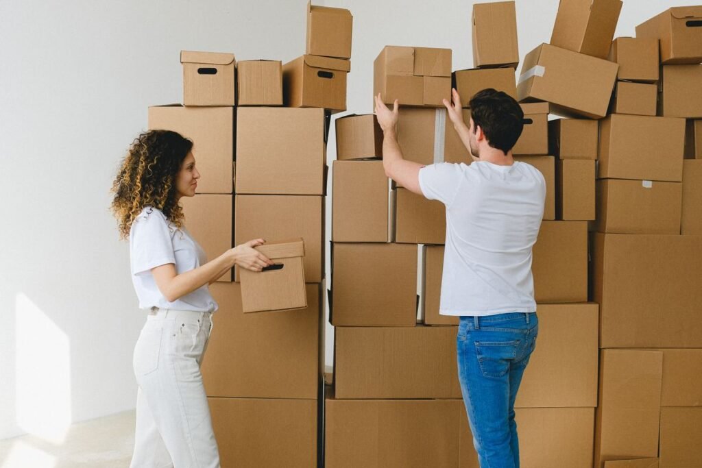 couple unpacking, carton boxes, household items, new apartment, modern apartment