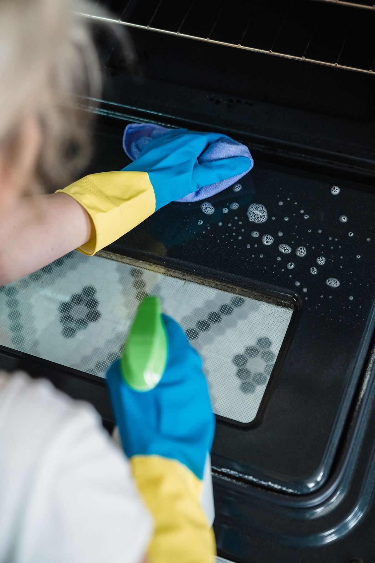 Cleaning an oven with a spray bottle and cloth