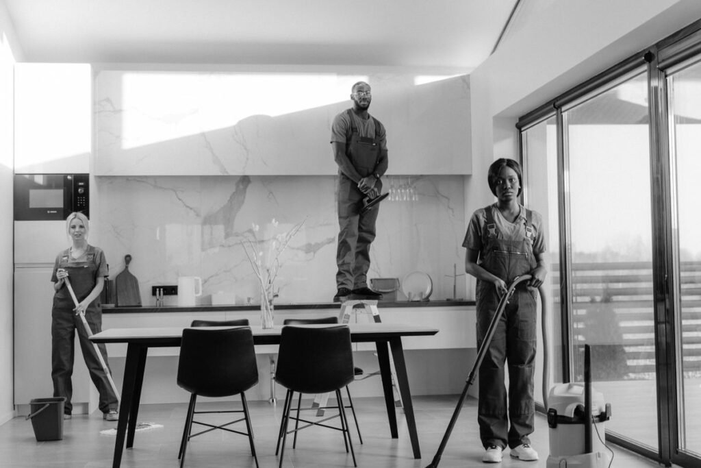 Professional cleaning crew of three in a modern kitchen