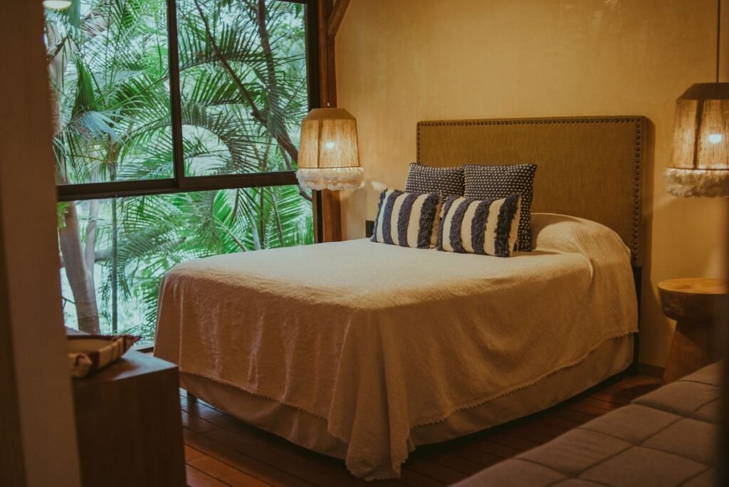Hotel Bedroom with Palm Leaves behind Window -