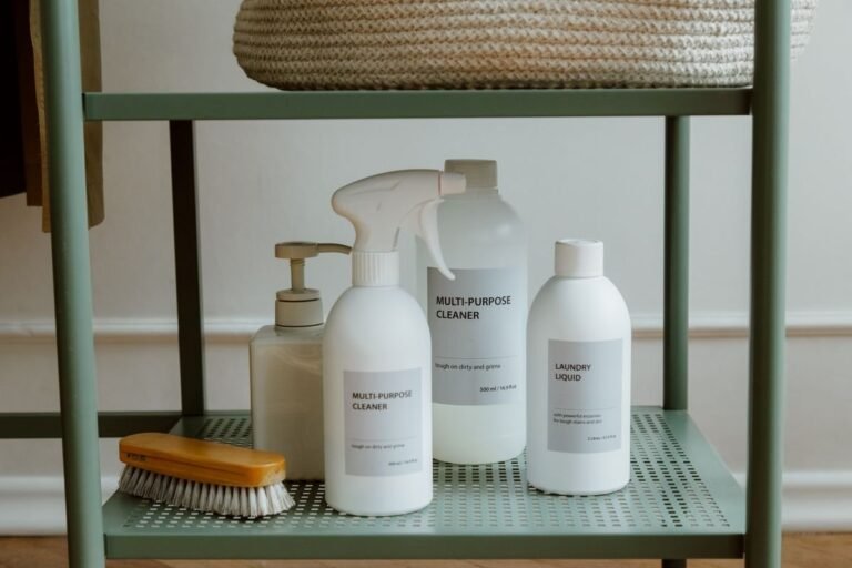 Neatly organized white laundry detergent bottles and cleaning supplies on a shelf